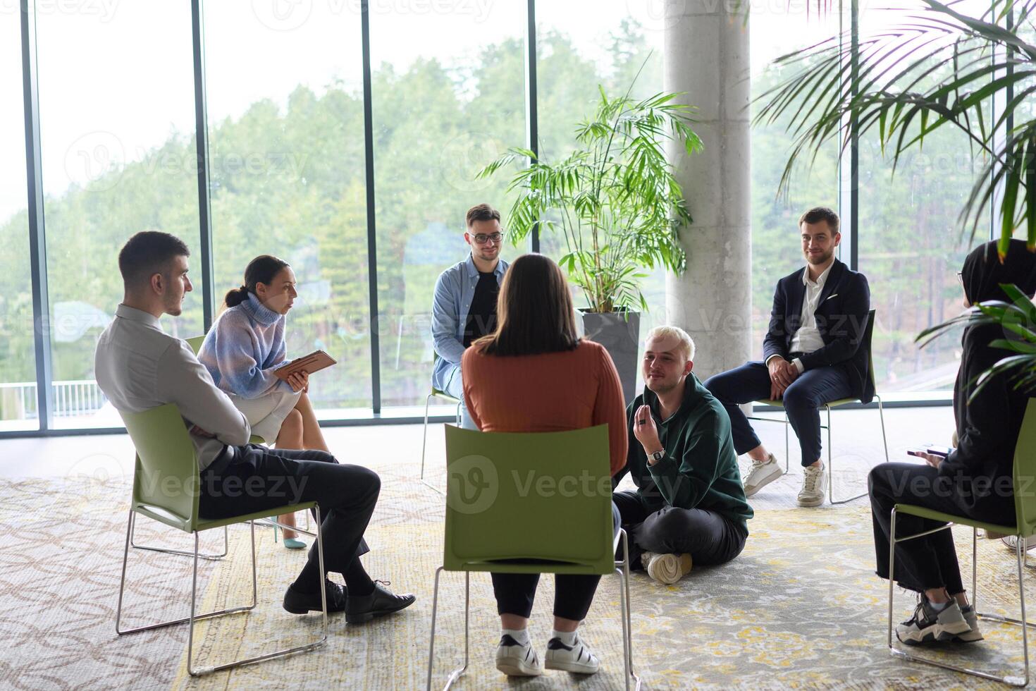 Corporate business team meeting with a manager or coach. Group of happy diverse, multiracial people sitting in a circle photo