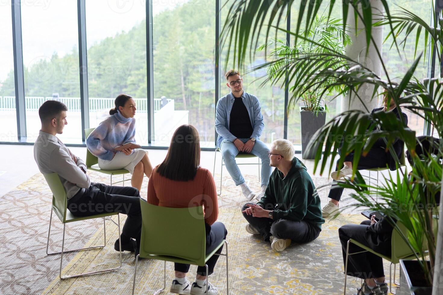 Corporate business team meeting with a manager or coach. Group of happy diverse, multiracial people sitting in a circle photo