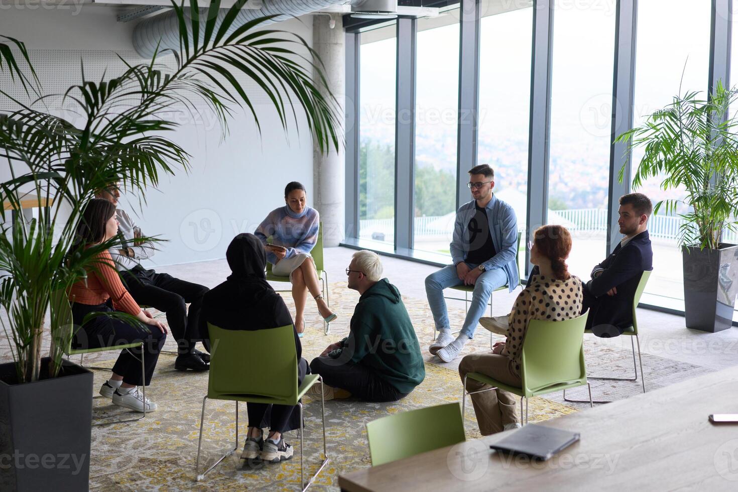 Corporate business team meeting with a manager or coach. Group of happy diverse, multiracial people sitting in a circle photo
