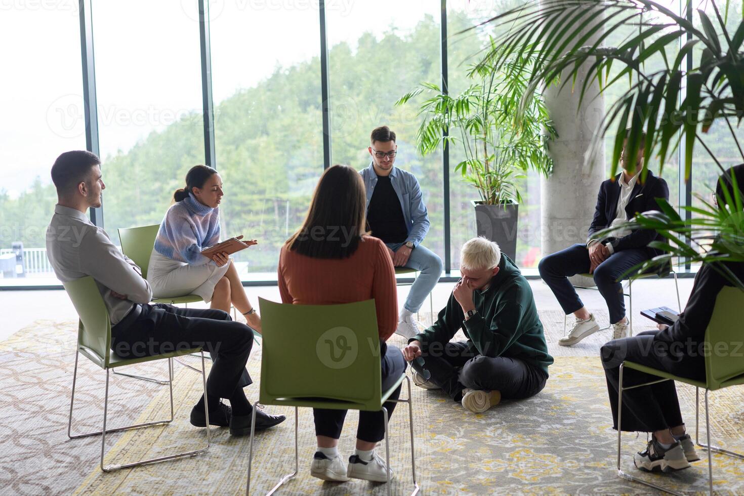 Corporate business team meeting with a manager or coach. Group of happy diverse, multiracial people sitting in a circle photo