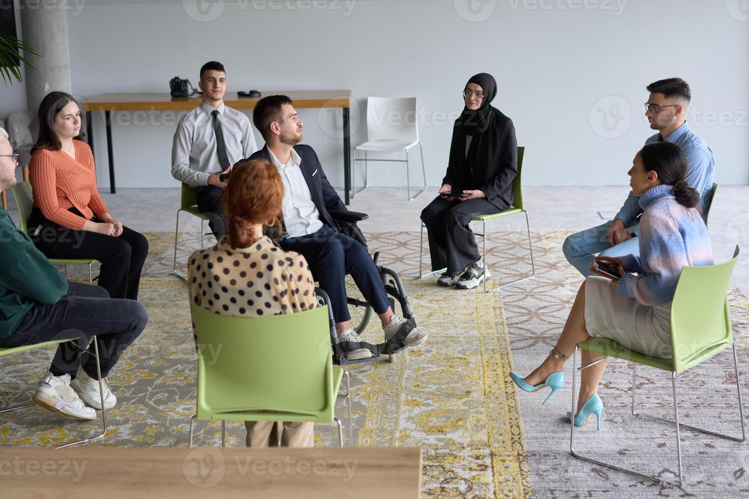Corporate business team meeting with a manager or coach. Group of happy diverse, multiracial people sitting in a circle photo