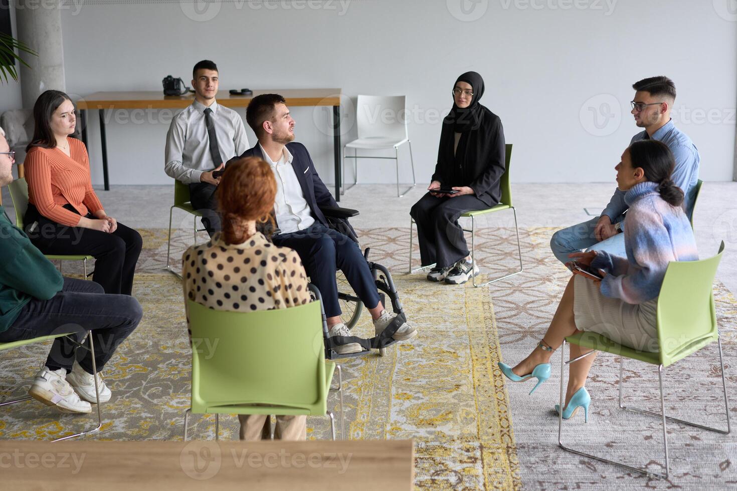 Corporate business team meeting with a manager or coach. Group of happy diverse, multiracial people sitting in a circle photo
