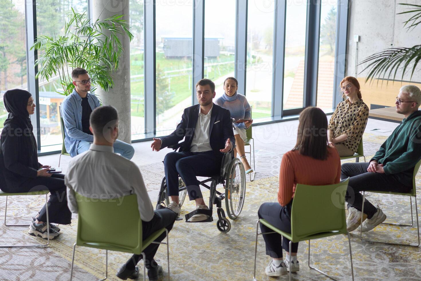 Corporate business team meeting with a manager or coach. Group of happy diverse, multiracial people sitting in a circle photo