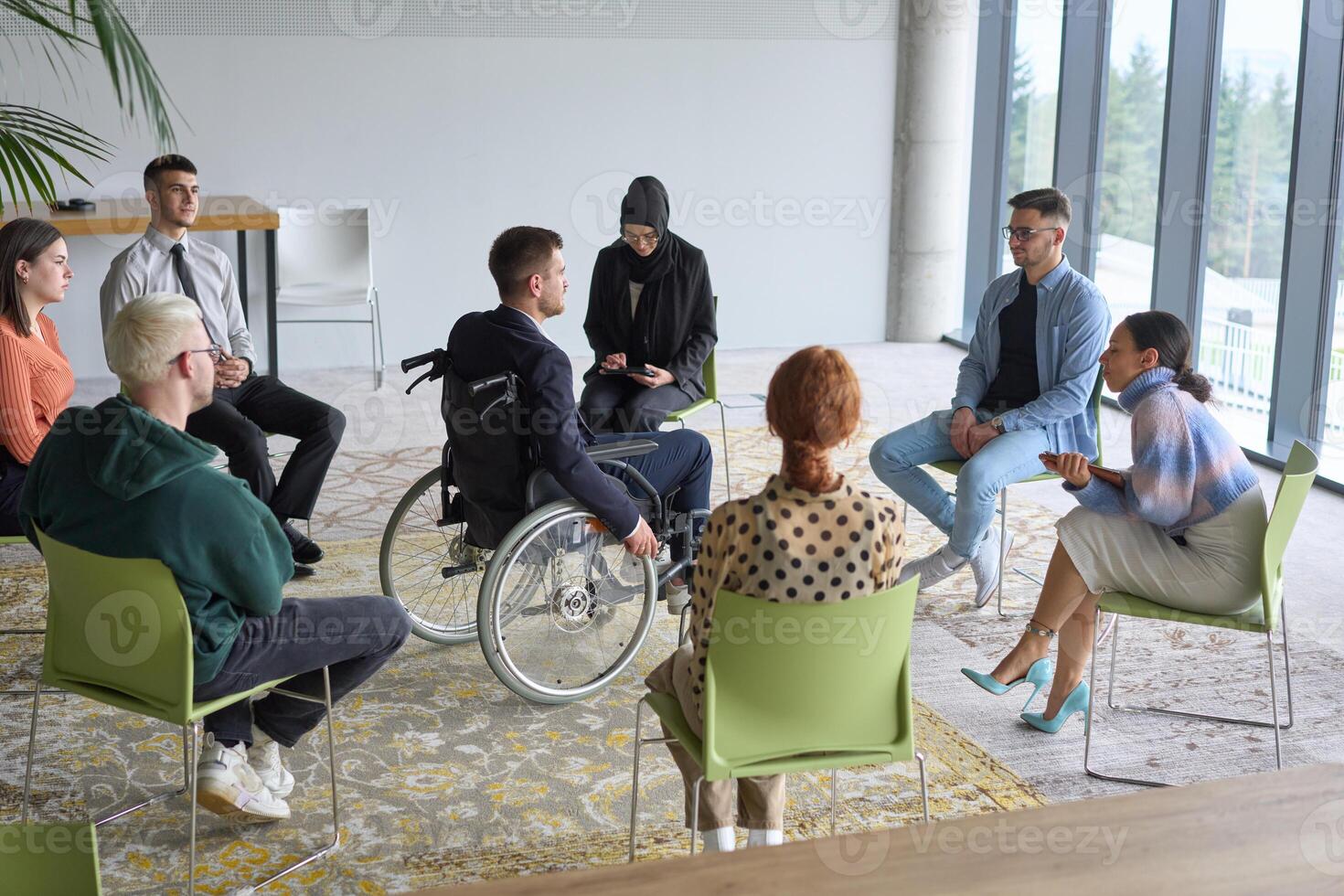 Corporate business team meeting with a manager or coach. Group of happy diverse, multiracial people sitting in a circle photo