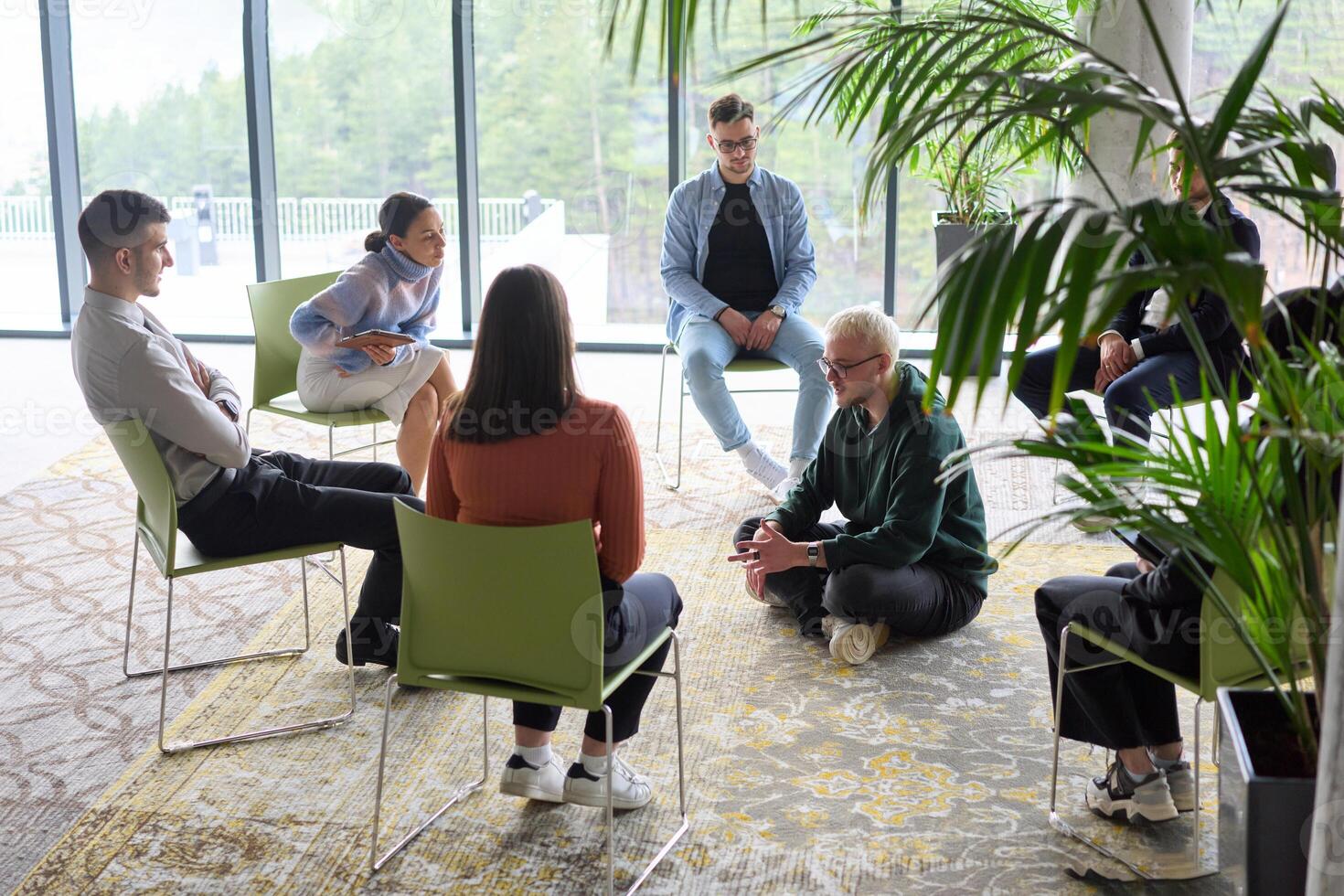Corporate business team meeting with a manager or coach. Group of happy diverse, multiracial people sitting in a circle photo