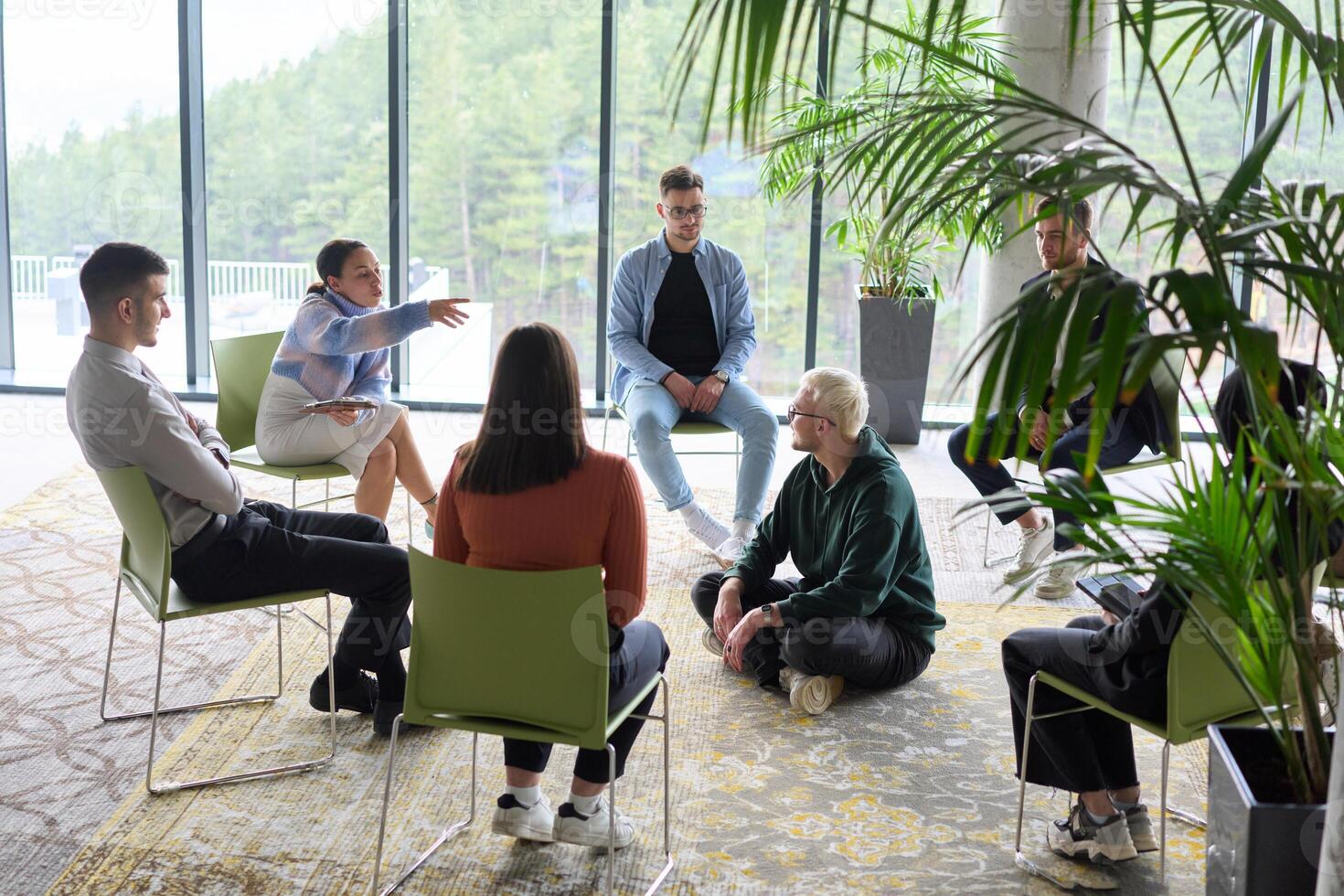Corporate business team meeting with a manager or coach. Group of happy diverse, multiracial people sitting in a circle photo
