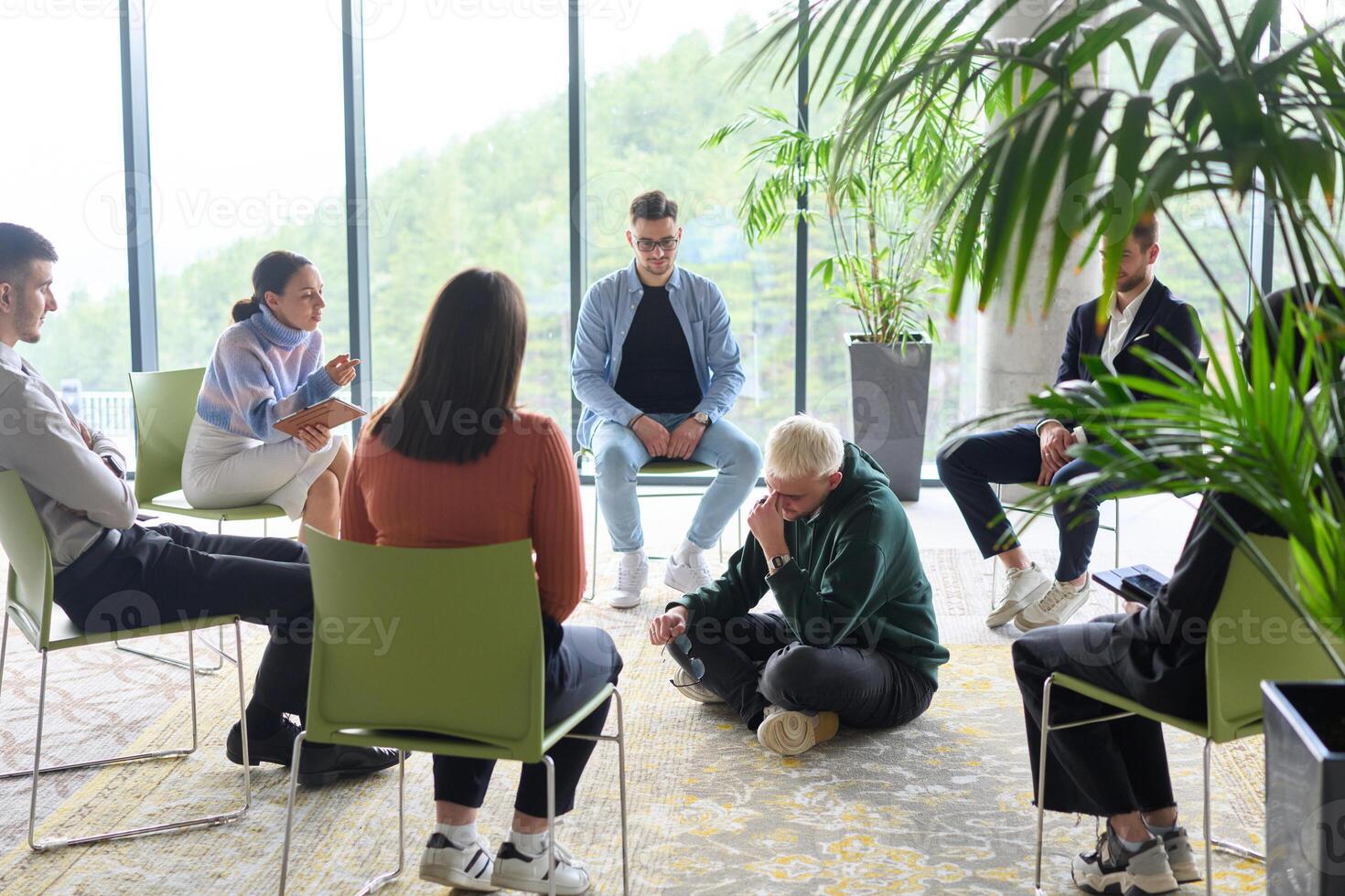 Corporate business team meeting with a manager or coach. Group of happy diverse, multiracial people sitting in a circle photo