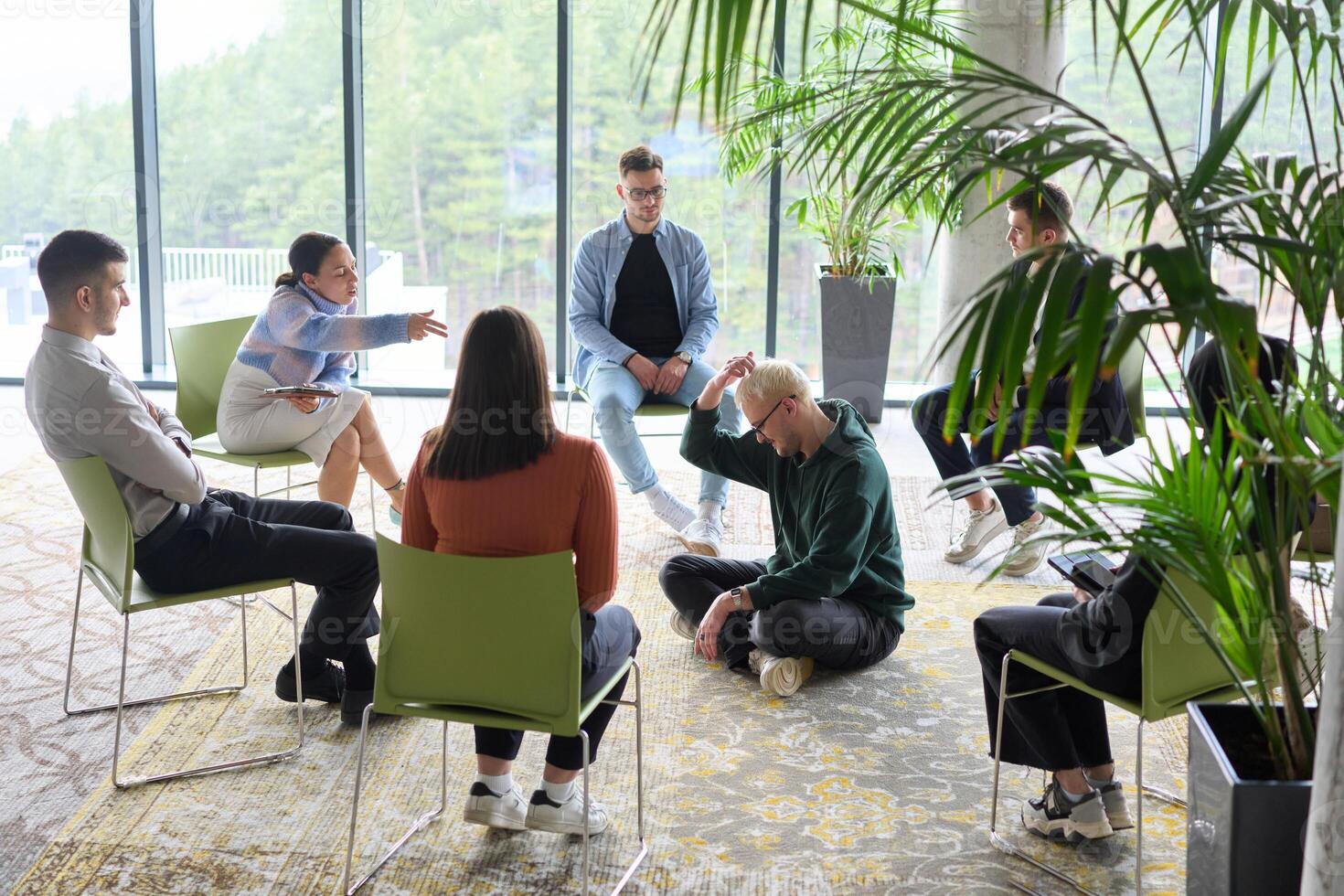 Corporate business team meeting with a manager or coach. Group of happy diverse, multiracial people sitting in a circle photo