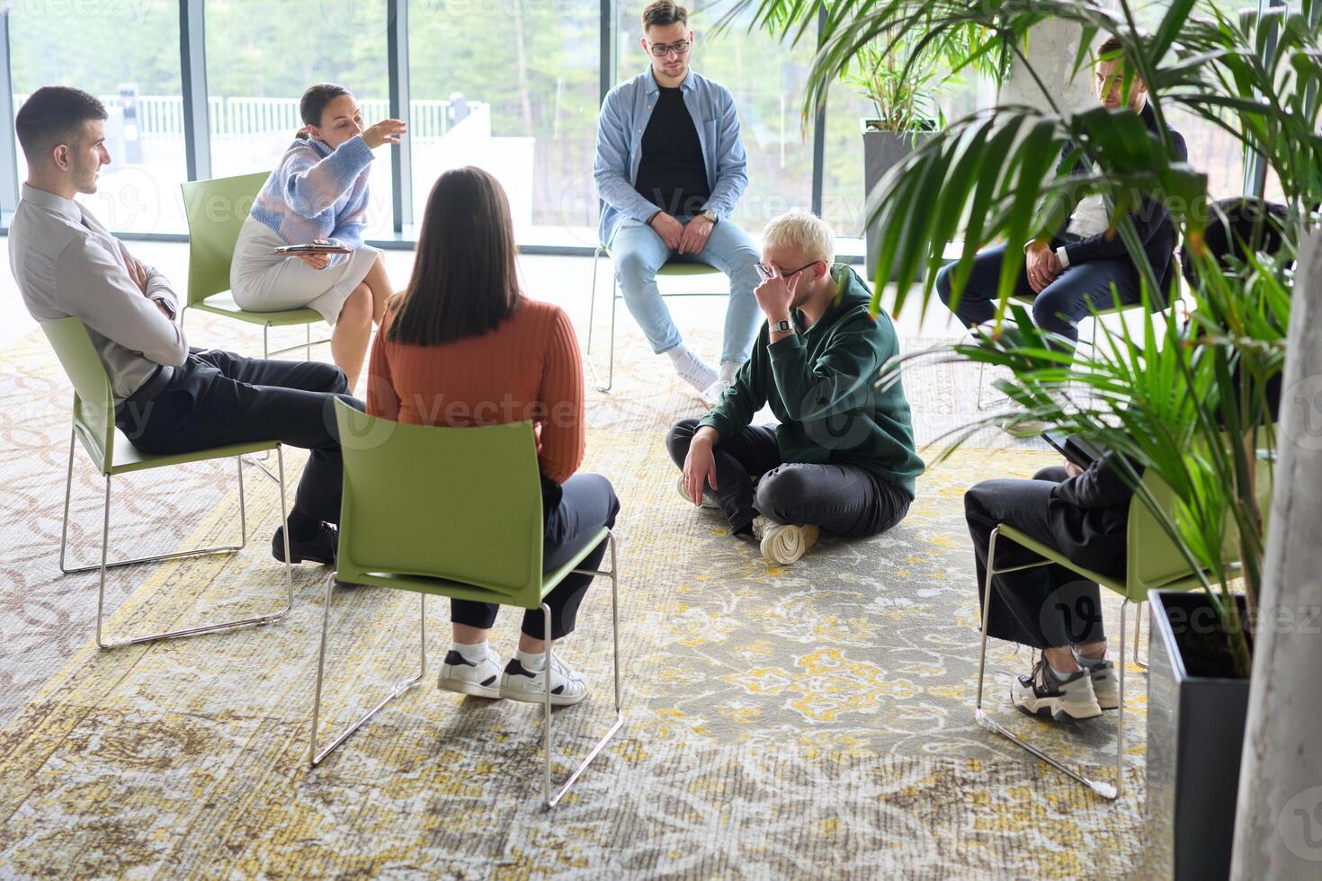 Corporate business team meeting with a manager or coach. Group of happy diverse, multiracial people sitting in a circle photo
