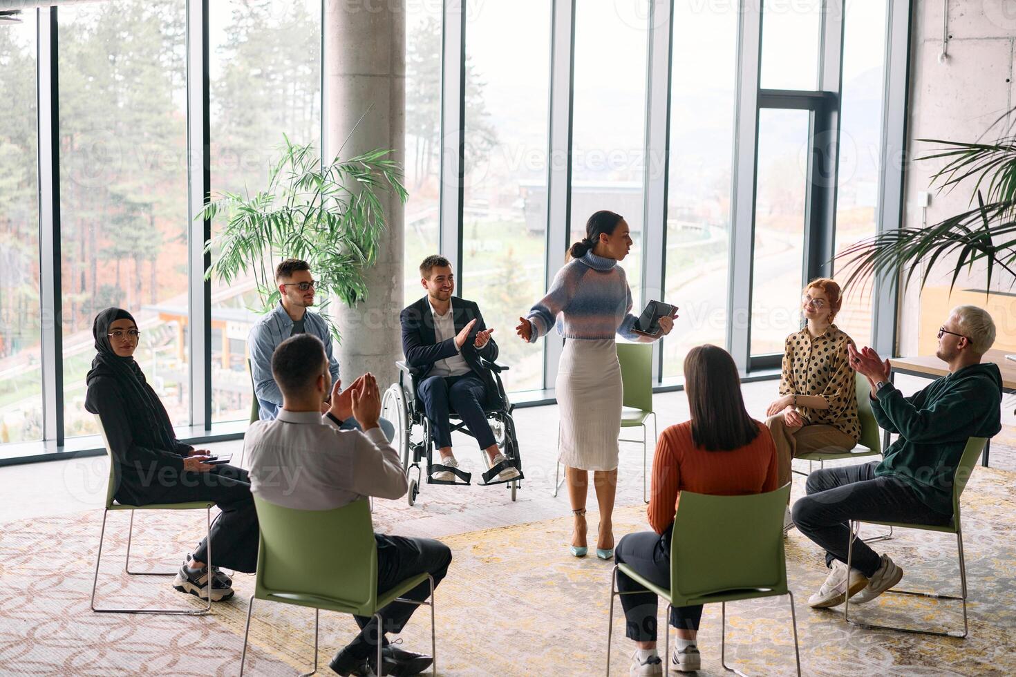 Corporate business team meeting with a manager or coach. Group of happy diverse, multiracial people sitting in a circle photo