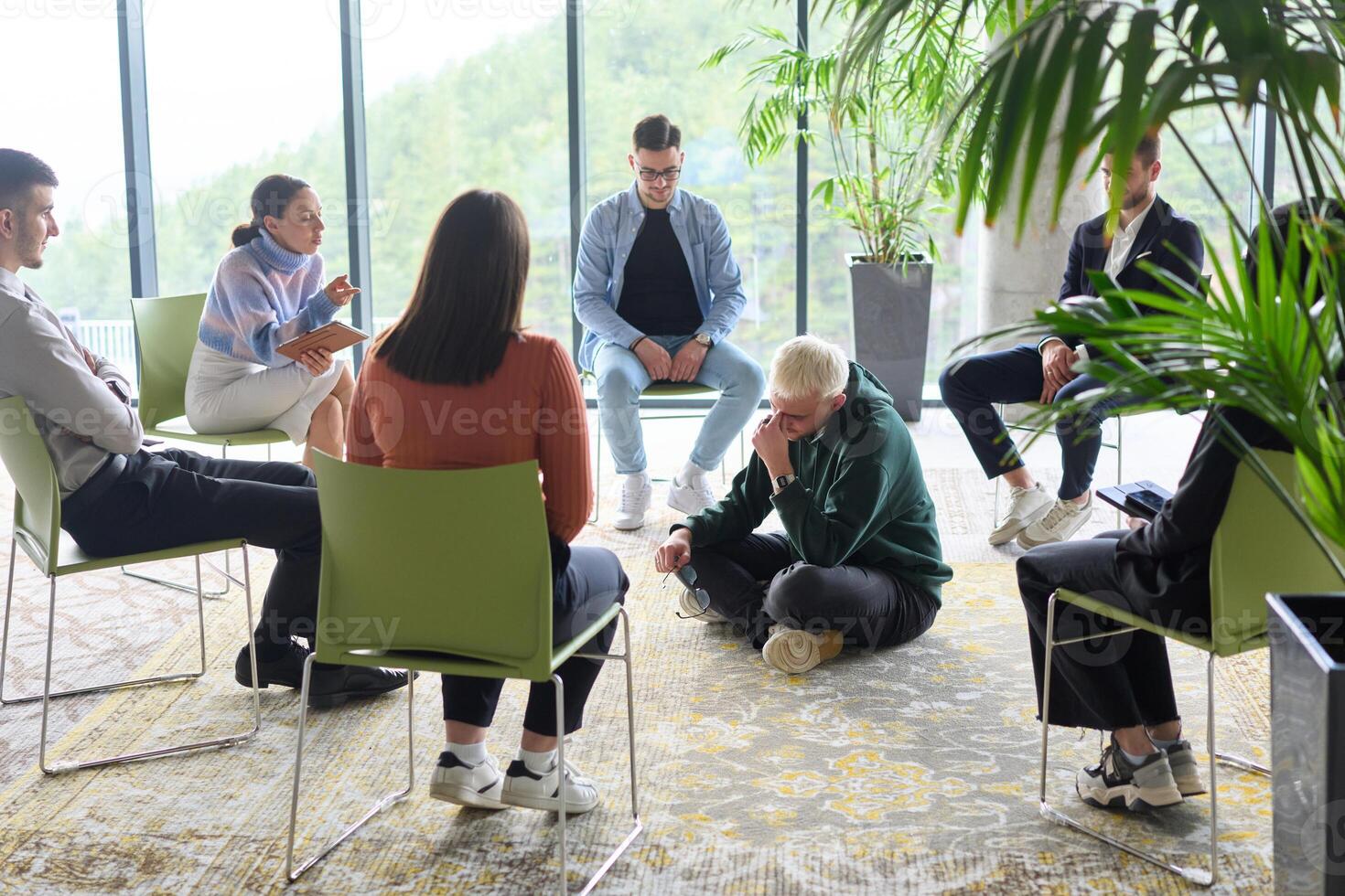 Corporate business team meeting with a manager or coach. Group of happy diverse, multiracial people sitting in a circle photo