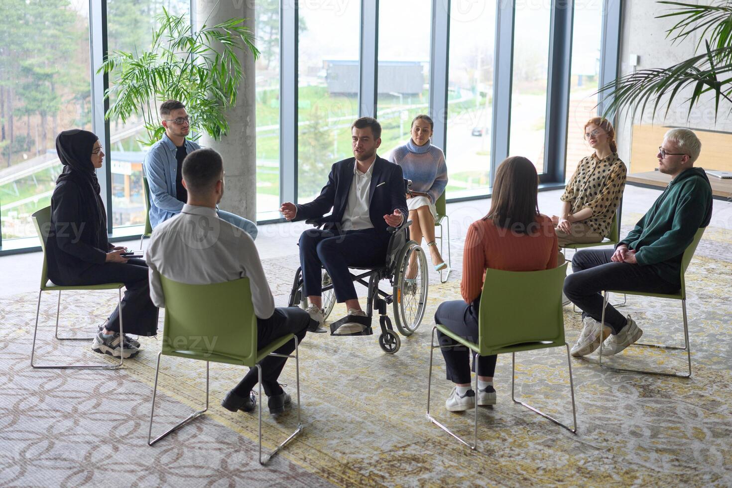 Corporate business team meeting with a manager or coach. Group of happy diverse, multiracial people sitting in a circle photo