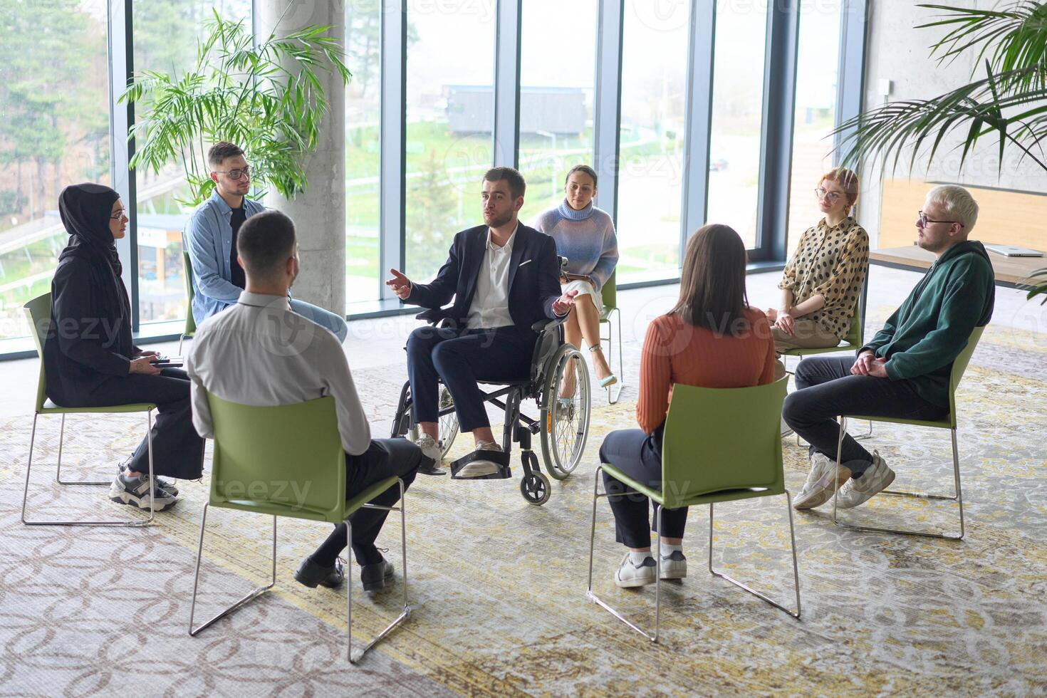 Corporate business team meeting with a manager or coach. Group of happy diverse, multiracial people sitting in a circle photo