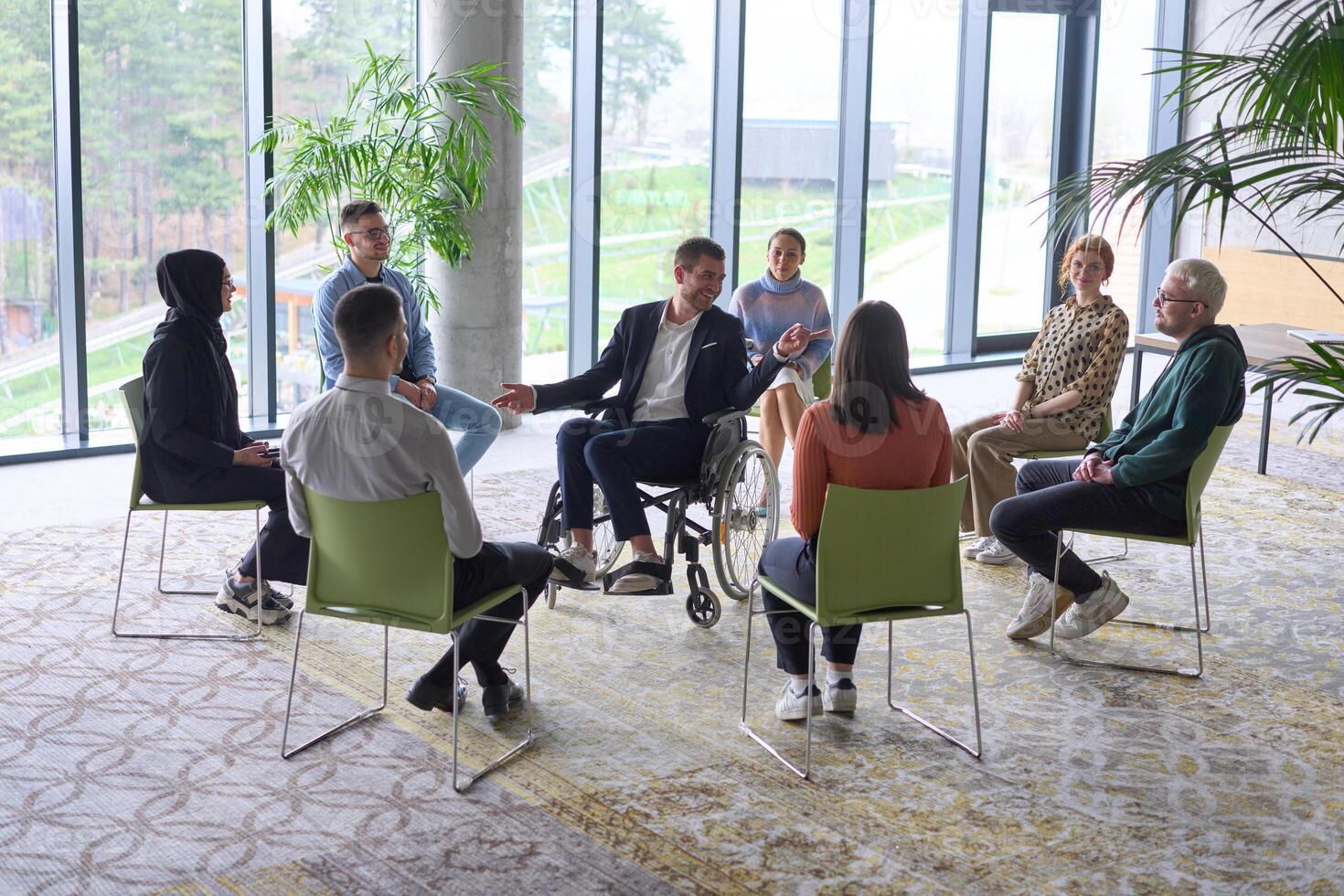 Corporate business team meeting with a manager or coach. Group of happy diverse, multiracial people sitting in a circle photo