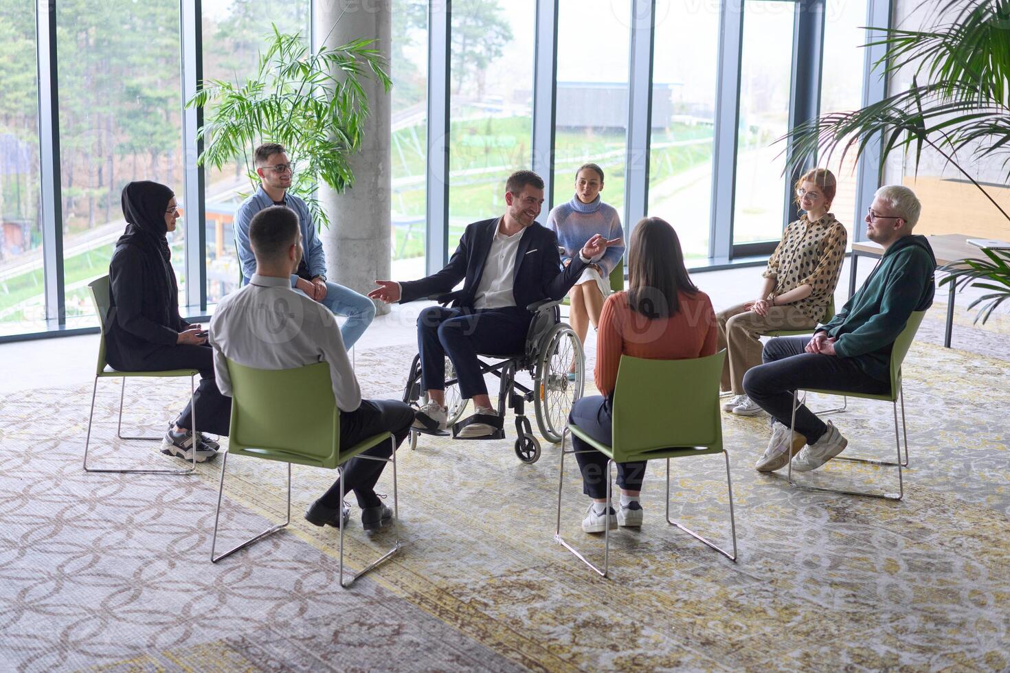 Corporate business team meeting with a manager or coach. Group of happy diverse, multiracial people sitting in a circle photo