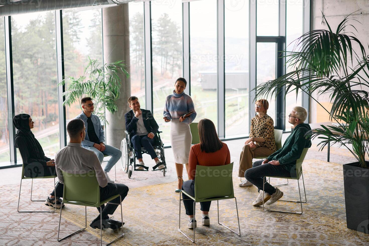 Corporate business team meeting with a manager or coach. Group of happy diverse, multiracial people sitting in a circle photo