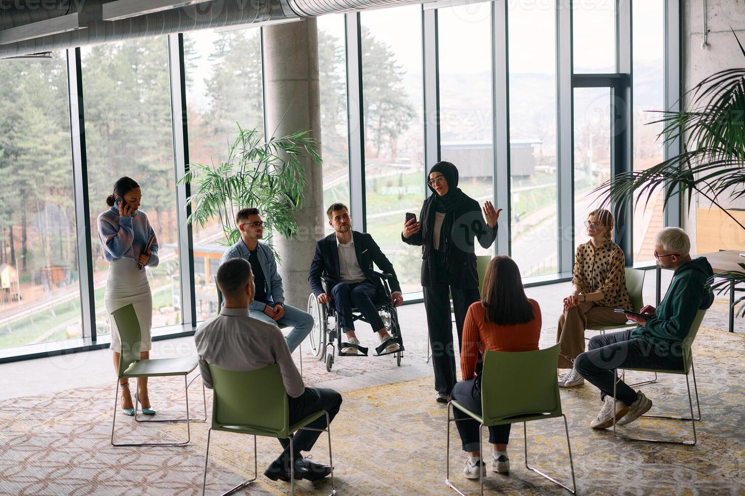 Corporate business team meeting with a manager or coach. Group of happy diverse, multiracial people sitting in a circle photo