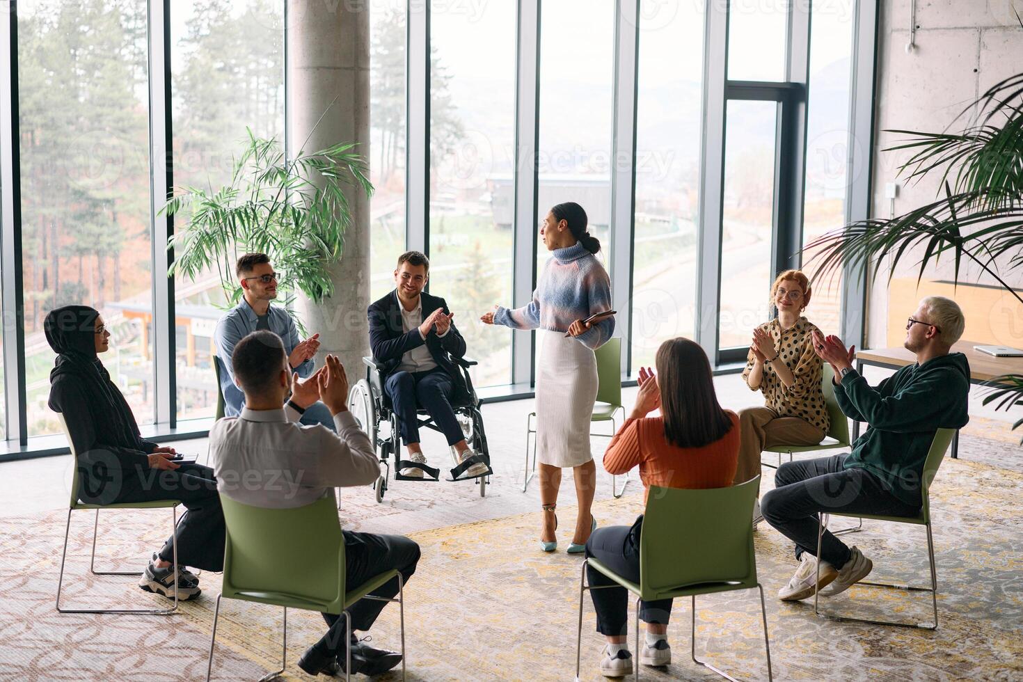 Corporate business team meeting with a manager or coach. Group of happy diverse, multiracial people sitting in a circle photo