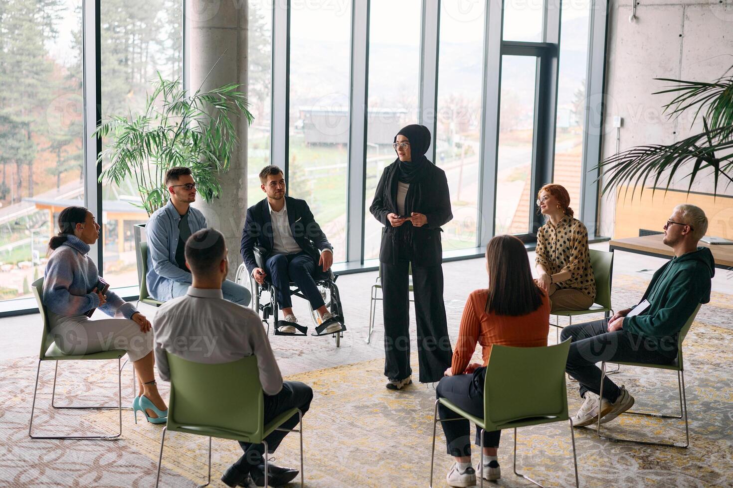 Corporate business team meeting with a manager or coach. Group of happy diverse, multiracial people sitting in a circle photo