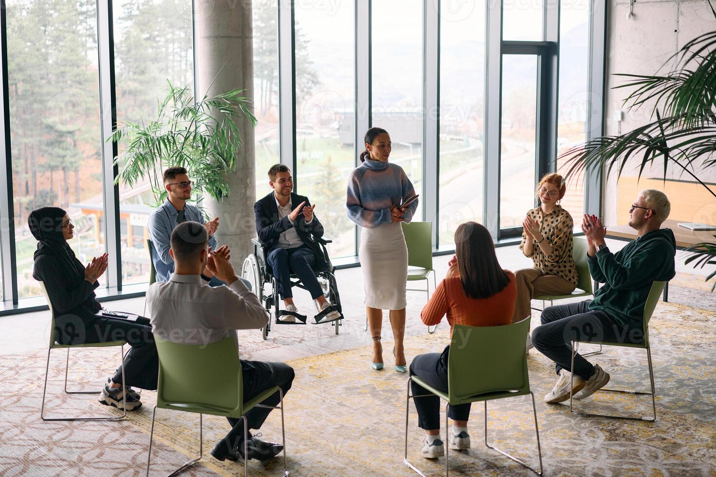 Corporate business team meeting with a manager or coach. Group of happy diverse, multiracial people sitting in a circle photo