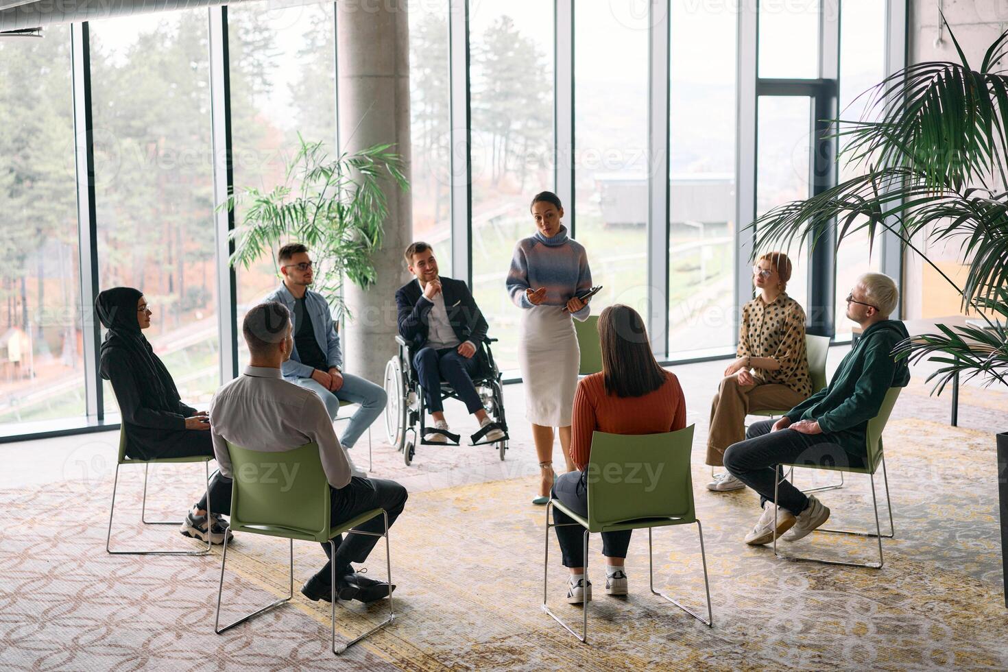 Corporate business team meeting with a manager or coach. Group of happy diverse, multiracial people sitting in a circle photo