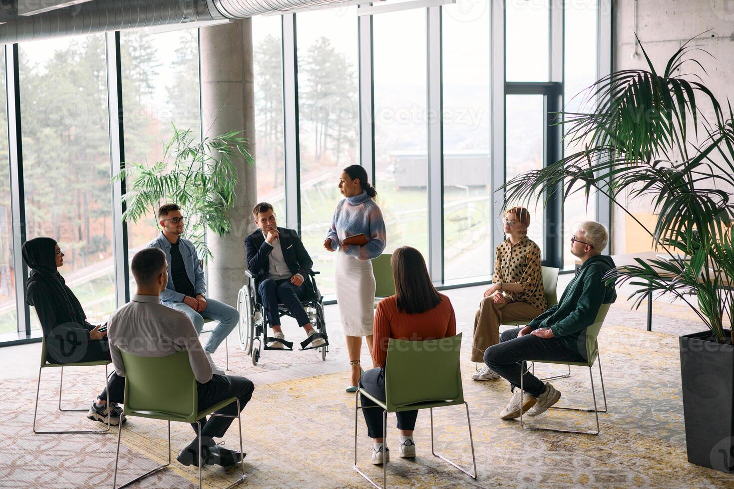 Corporate business team meeting with a manager or coach. Group of happy diverse, multiracial people sitting in a circle photo