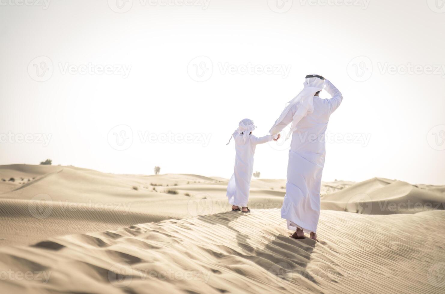 Saudi men and women in the Saudi desert photo