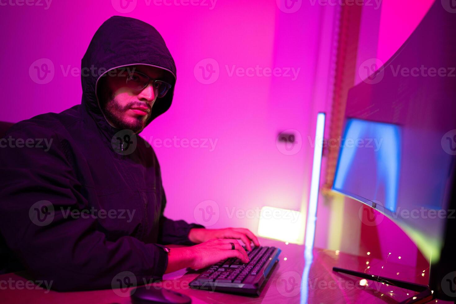 Black Hat Hacker hoodie concept at a laptop computer hacking the Internet. Cyber crime and security principles. photo