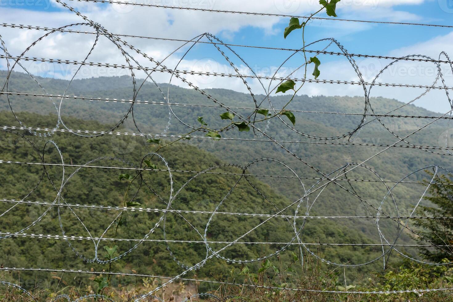 Border view between Iran and Azerbaijan with barbed wire and mountainous backdrop photo