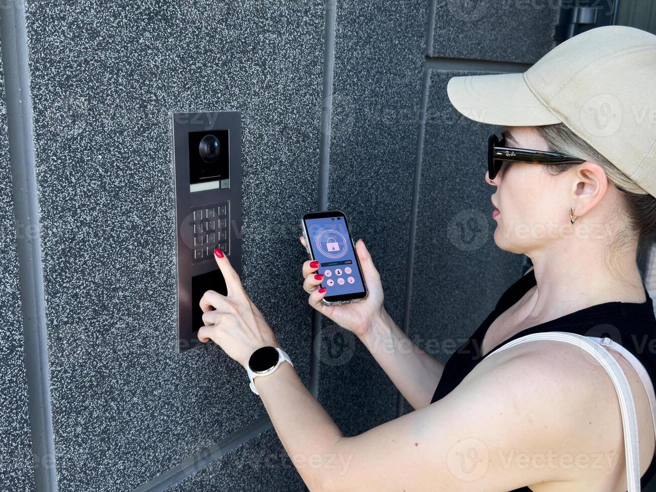 A Person's Hand Holding Smartphone For Disarming Security System Of Door photo