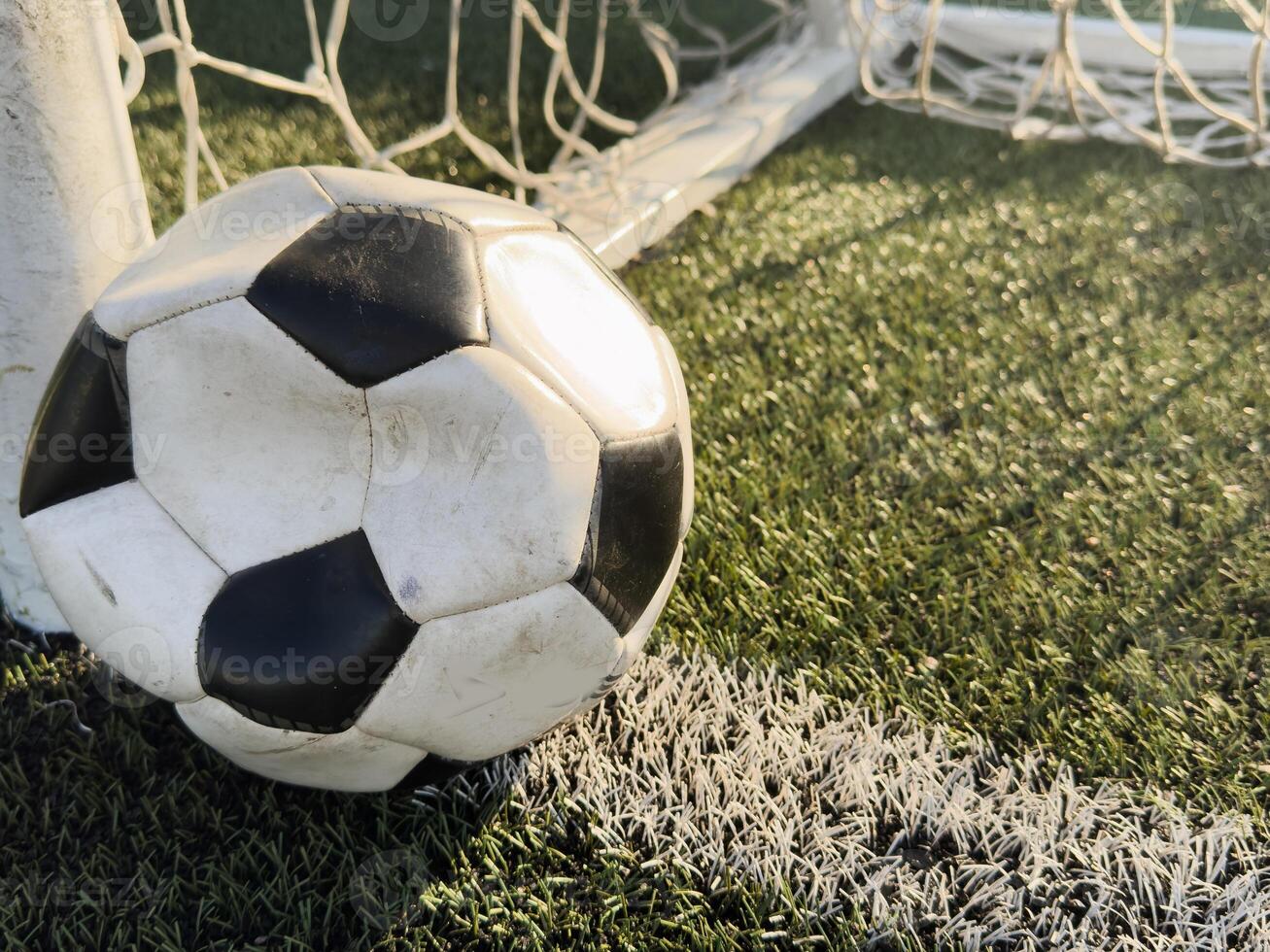 Deflated soccer ball on grass. Soccer concept. photo