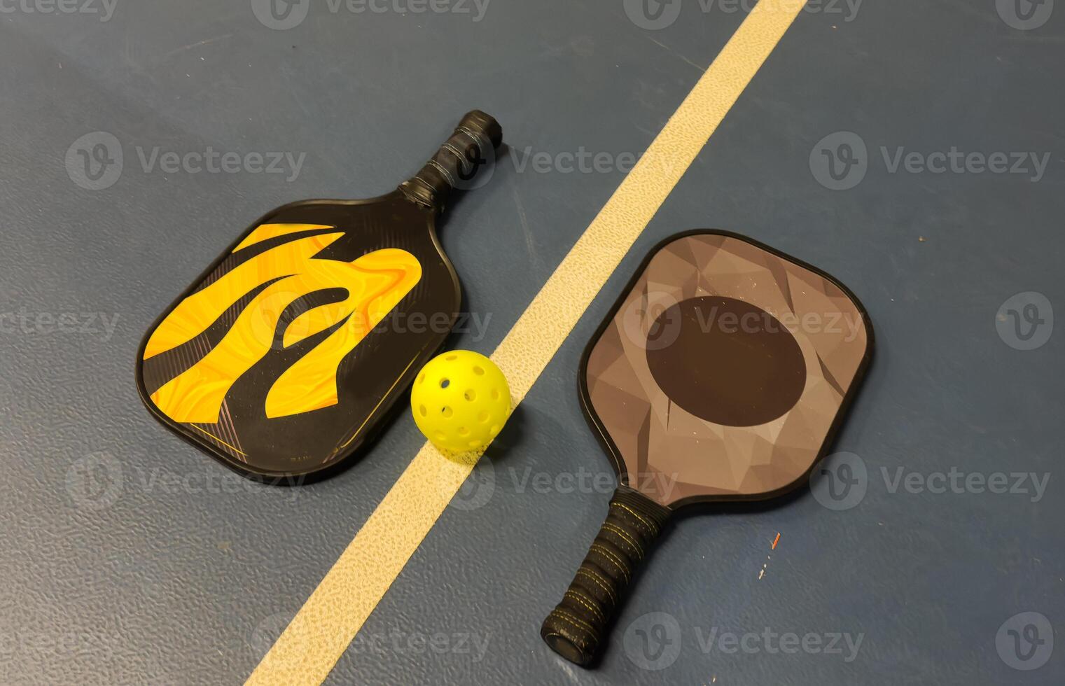A Pickleball Racquet's on blue court photo