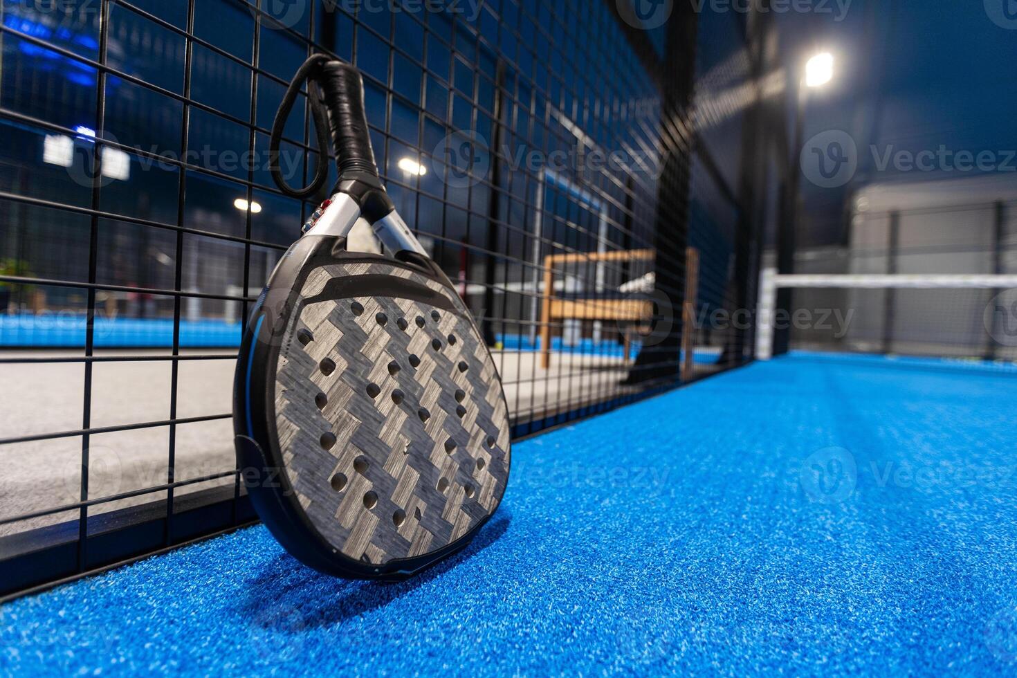 Black professional paddle tennis racket and ball with natural lighting on blue background. Horizontal sport theme poster, greeting cards, headers, website and app photo