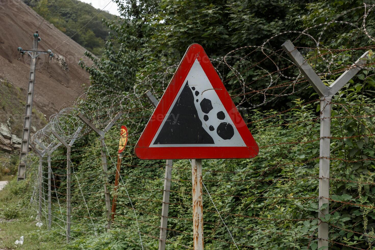 Warning sign near the border between Iran and Azerbaijan indicating landslide risk photo