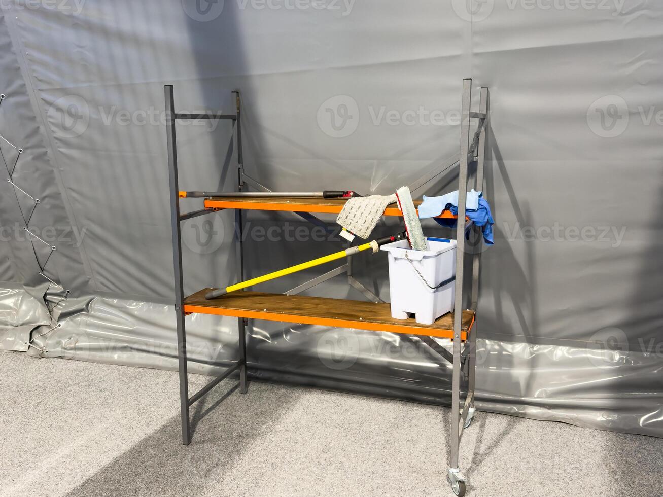Cleaning supplies cart wait for service. Bucket and set of cleaning equipment in department store or commercial building photo
