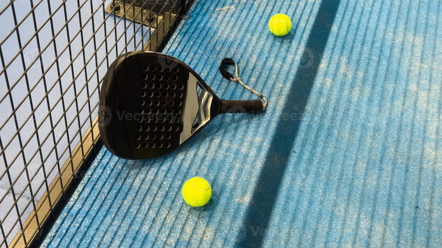 Ball in the shade of the net of a blue paddle tennis court. photo
