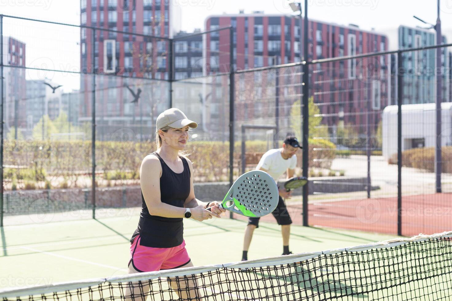 hands of a woman paddle player is holding balls and the racket at the background at the beginning of the match outdoors photo