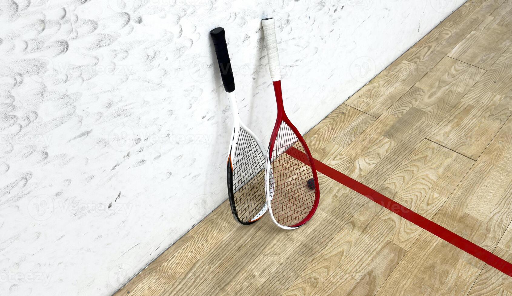 Squash rackets and ball on court floor, top view photo