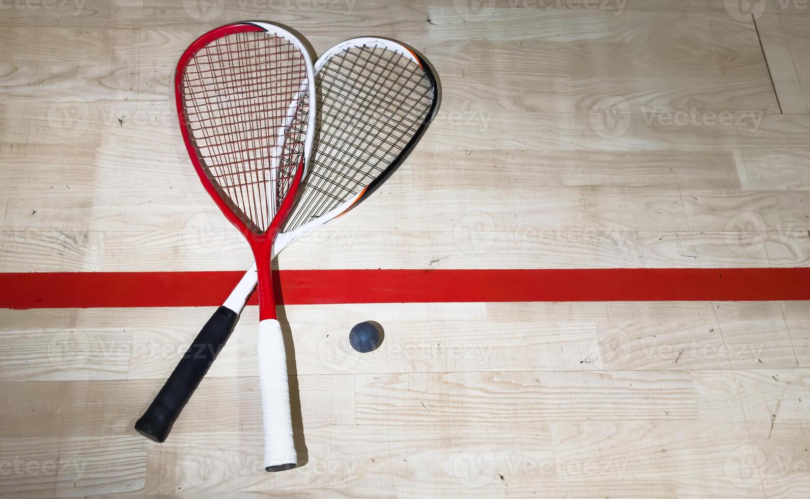 Squash Rackets And a Ball on a Wooden Court Floor. Sport Theme. photo