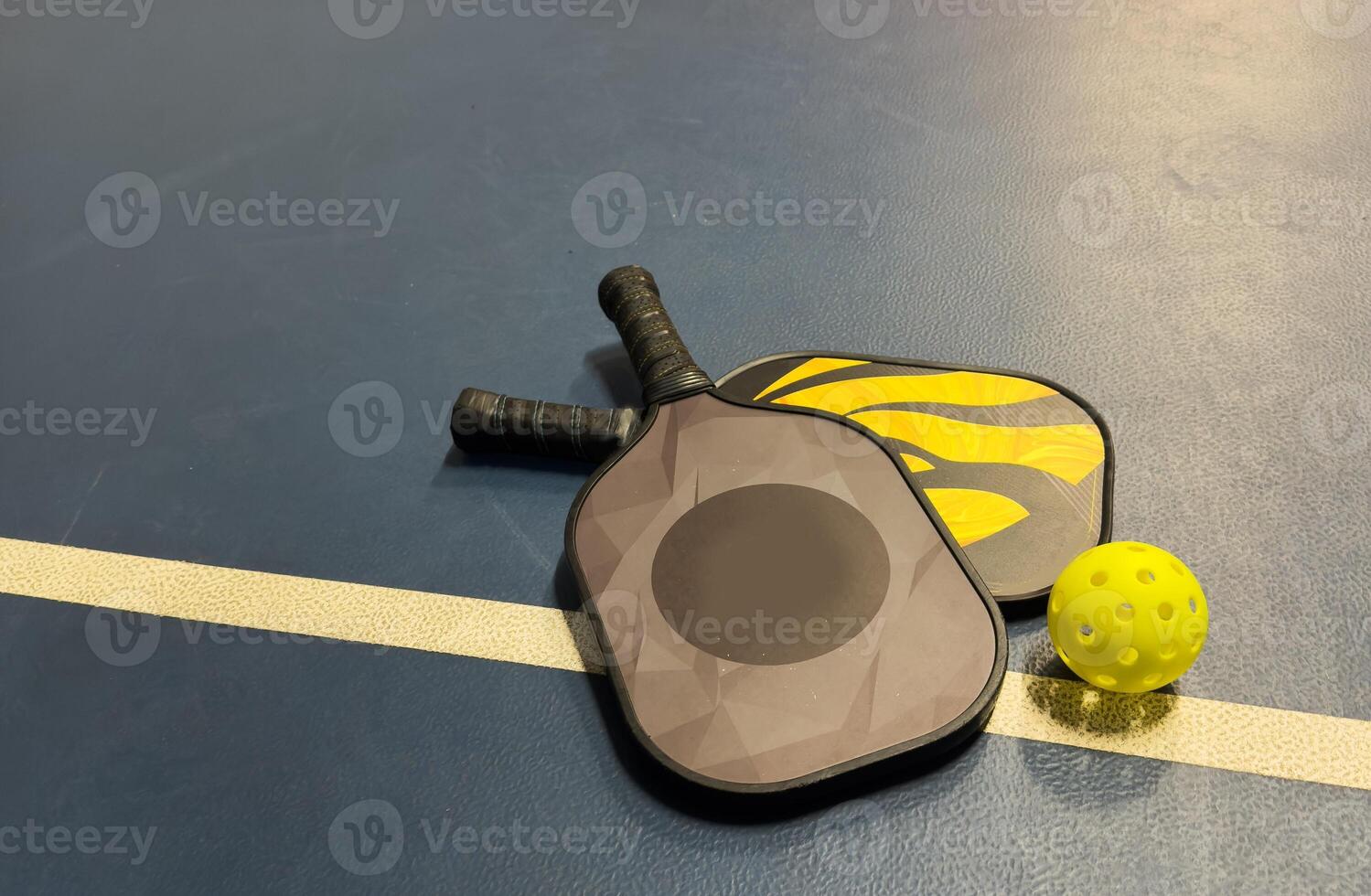 Pickleball tennis racket on the court. Blue background with copy space. Sport court and ball. photo