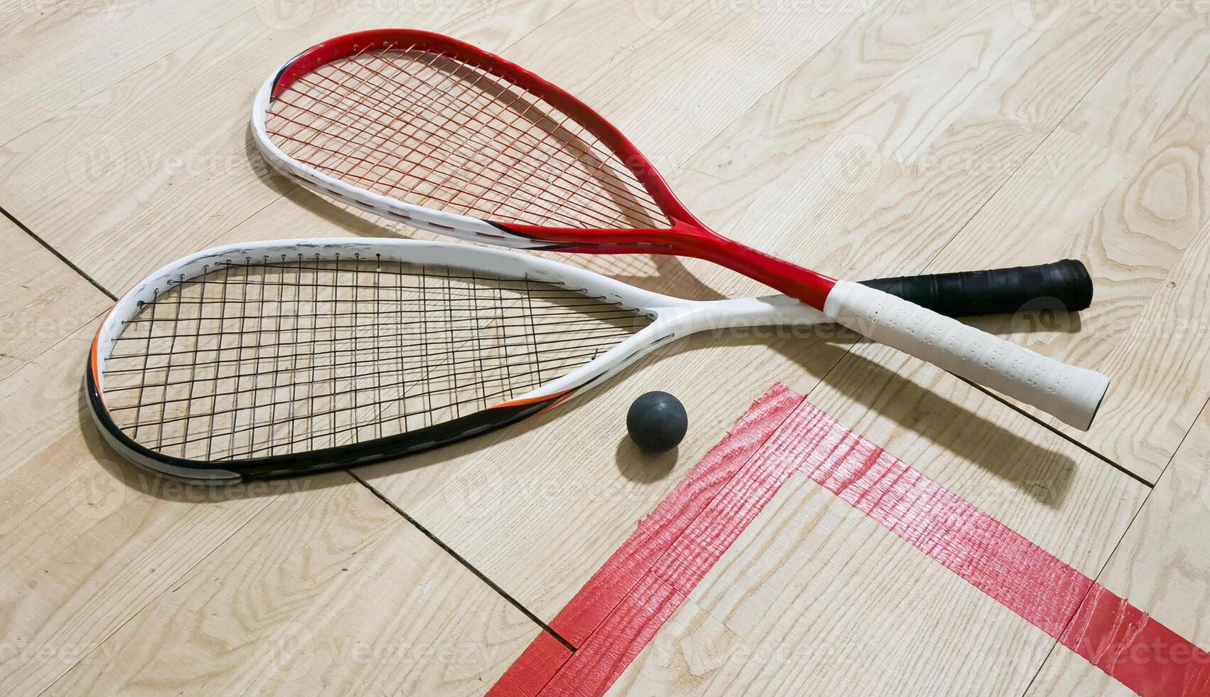 Squash Rackets And a Ball on a Wooden Court Floor. Sport Theme. photo