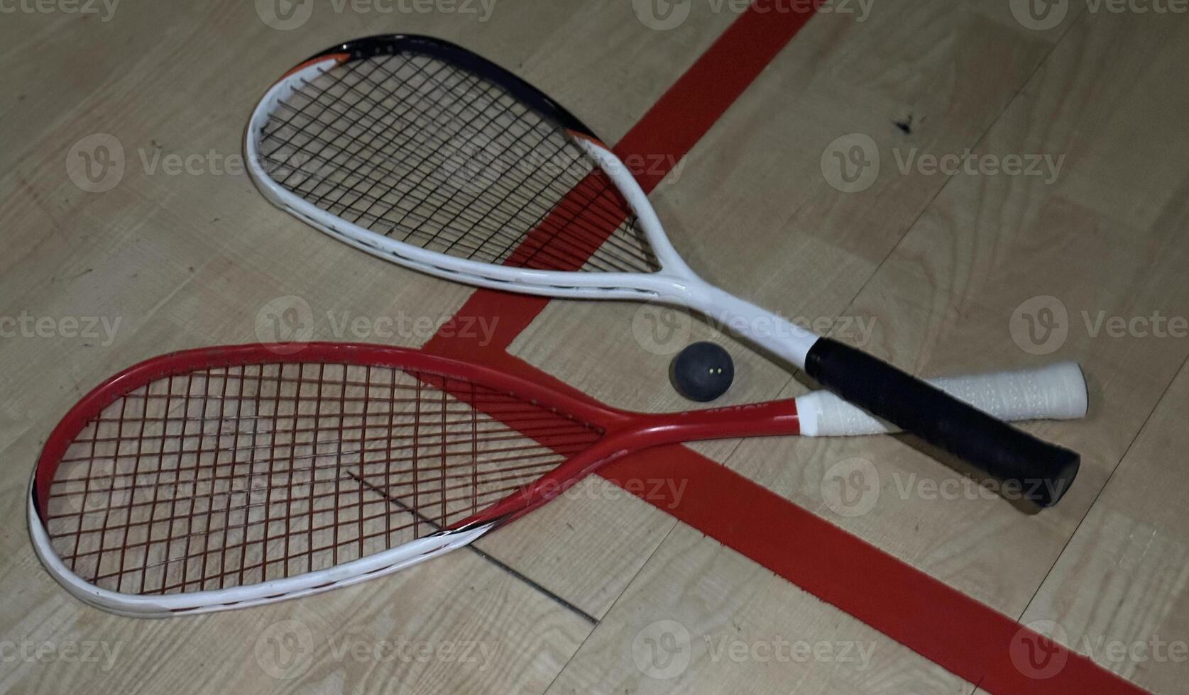 Squash rackets and ball on court floor, top view photo