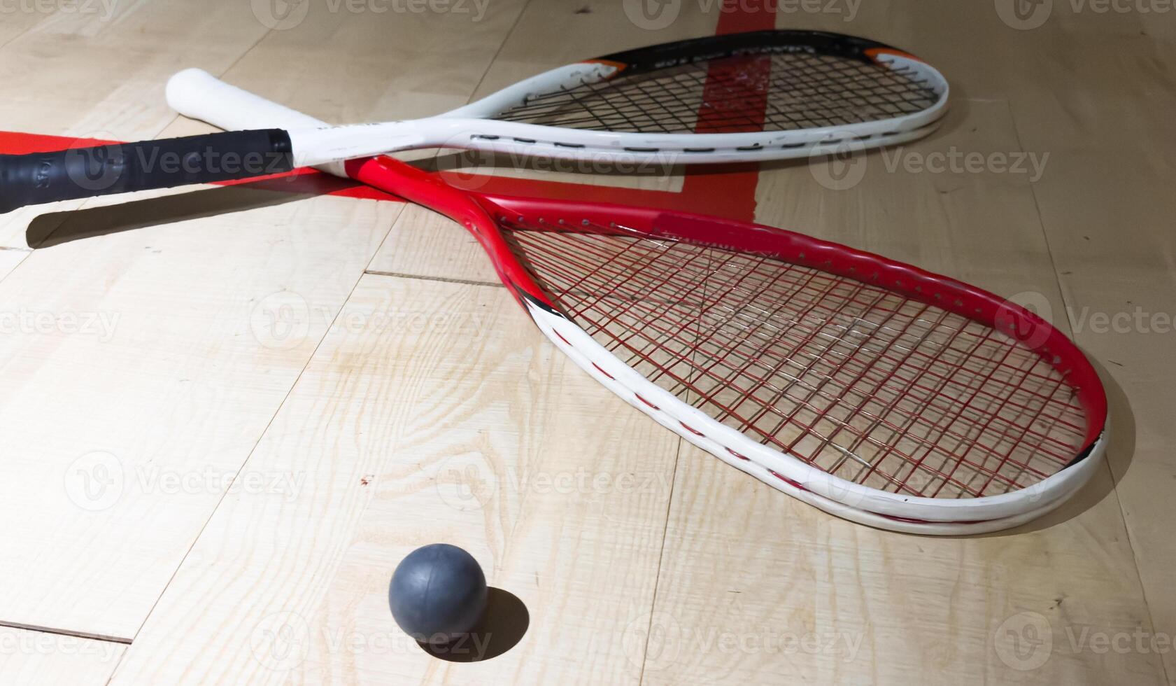 Empty squash court and rackets on the wooden floor. photo