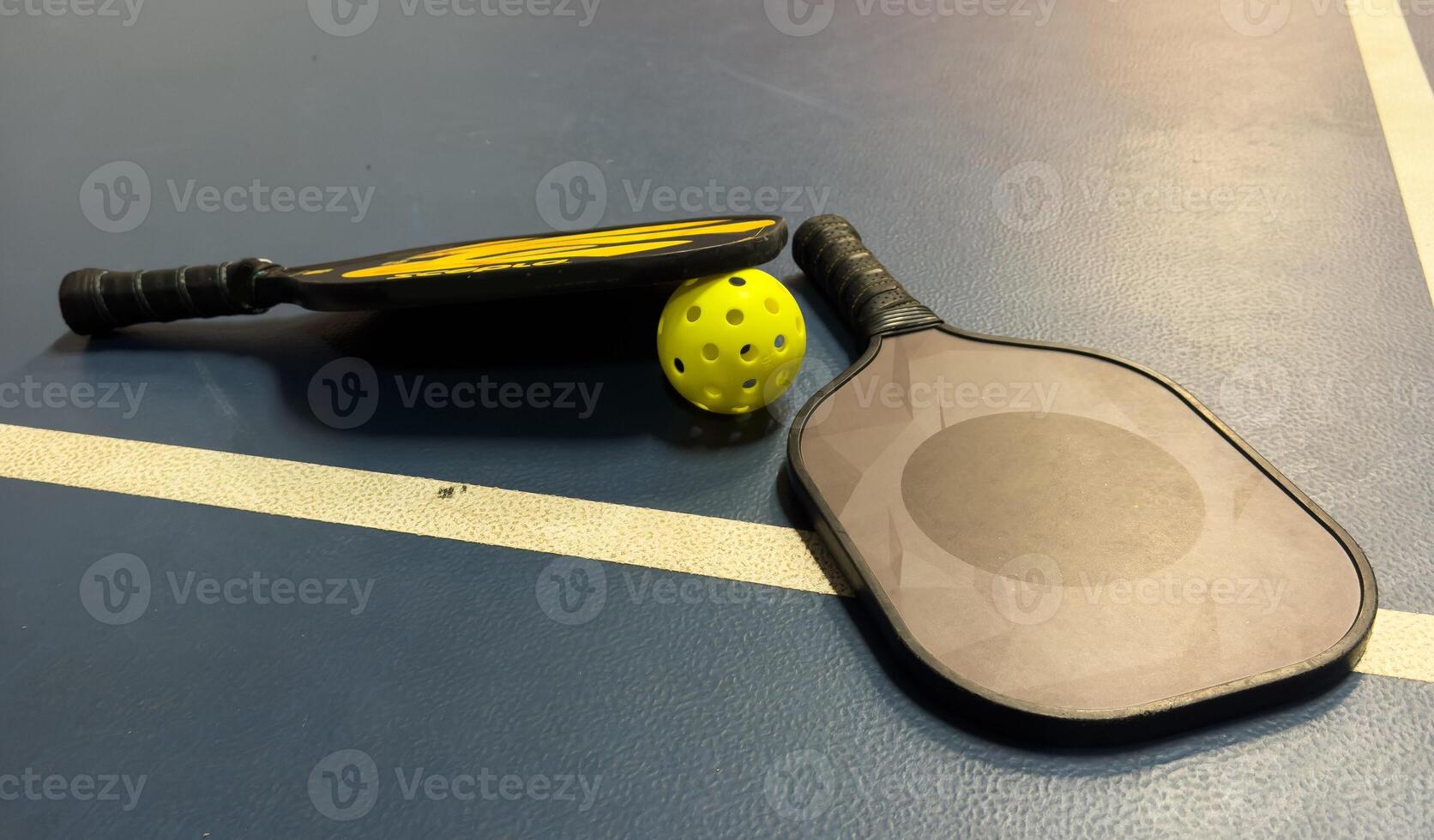 Pickleball tennis racket on the court. Blue background with copy space. Sport court and ball. photo