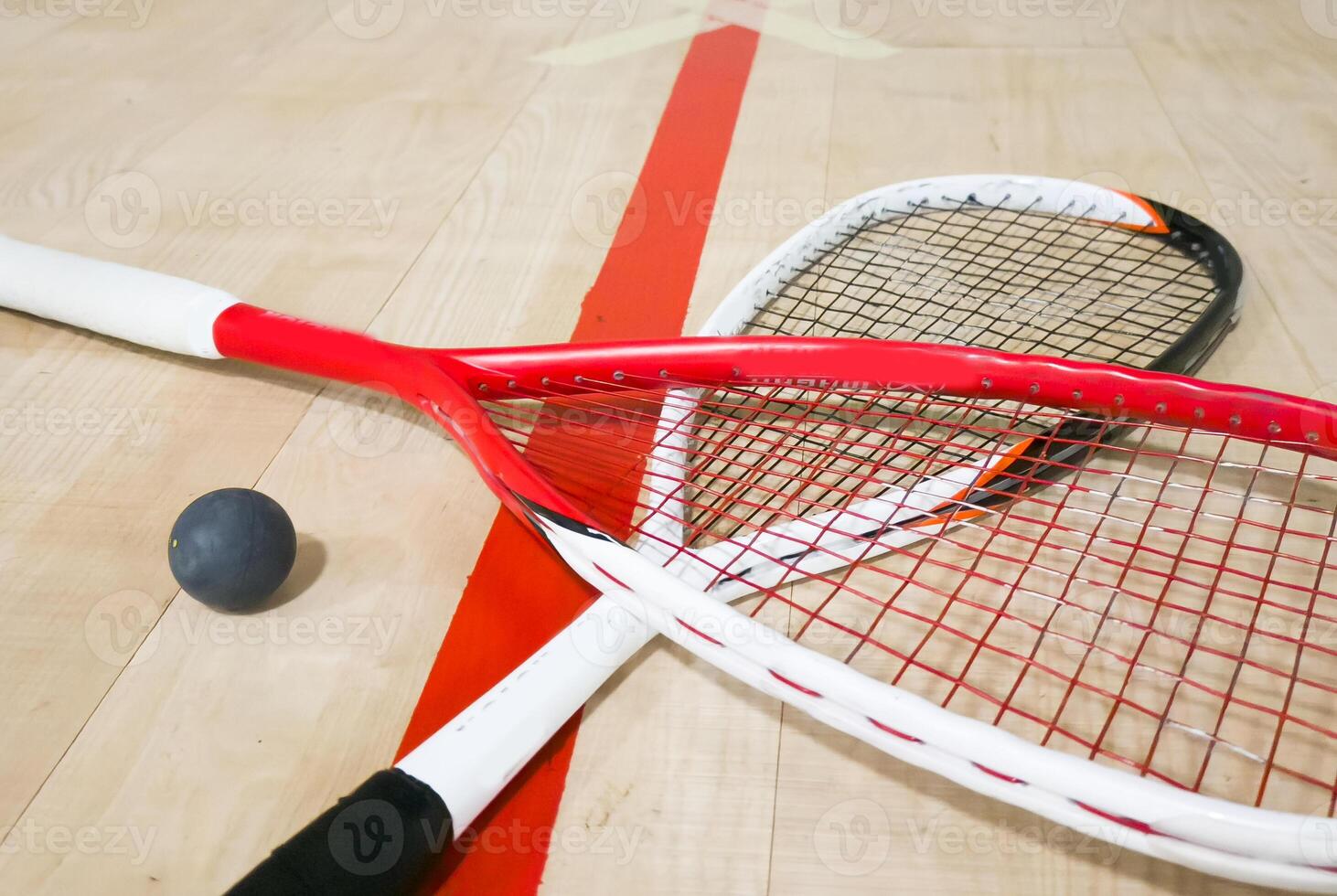 Squash Rackets And a Ball on a Wooden Court Floor. Sport Theme. photo
