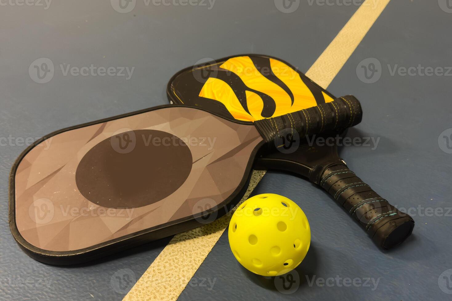 A Pickleball Racquet's on blue court photo