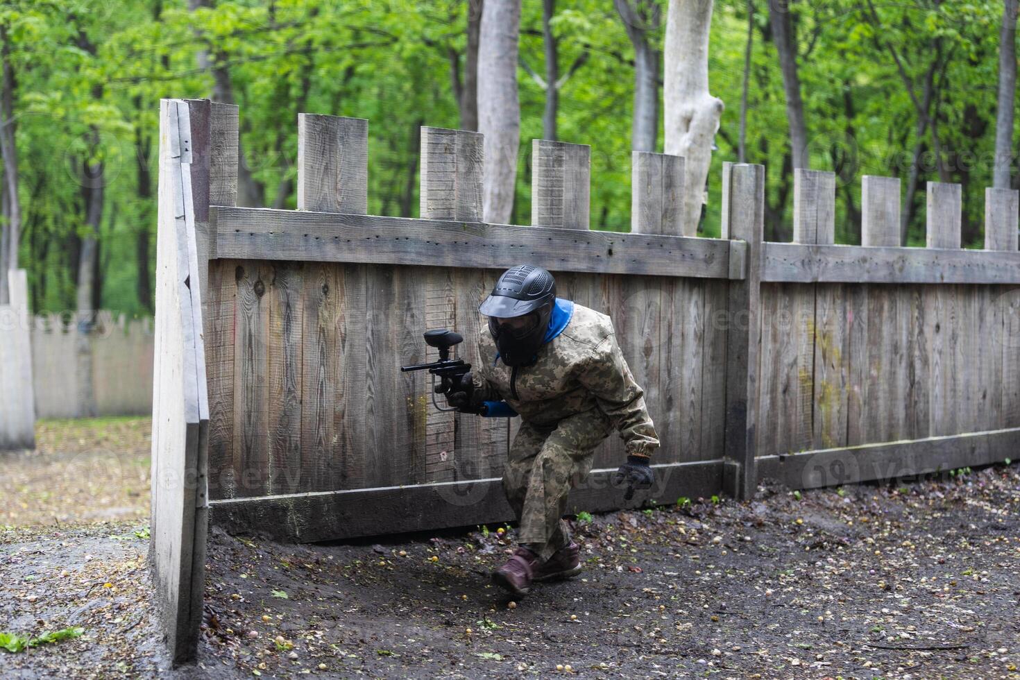 Warriors in camouflage and masks playing paintball photo