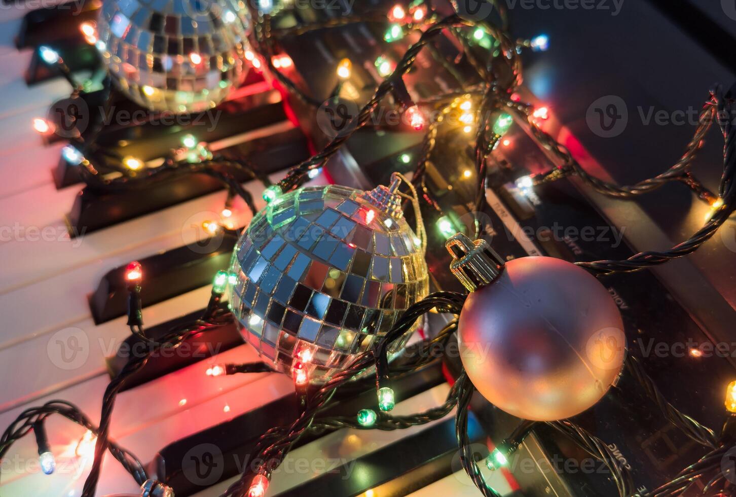 Chritmas balls and gift boxes on classical piano keyboard, front view photo