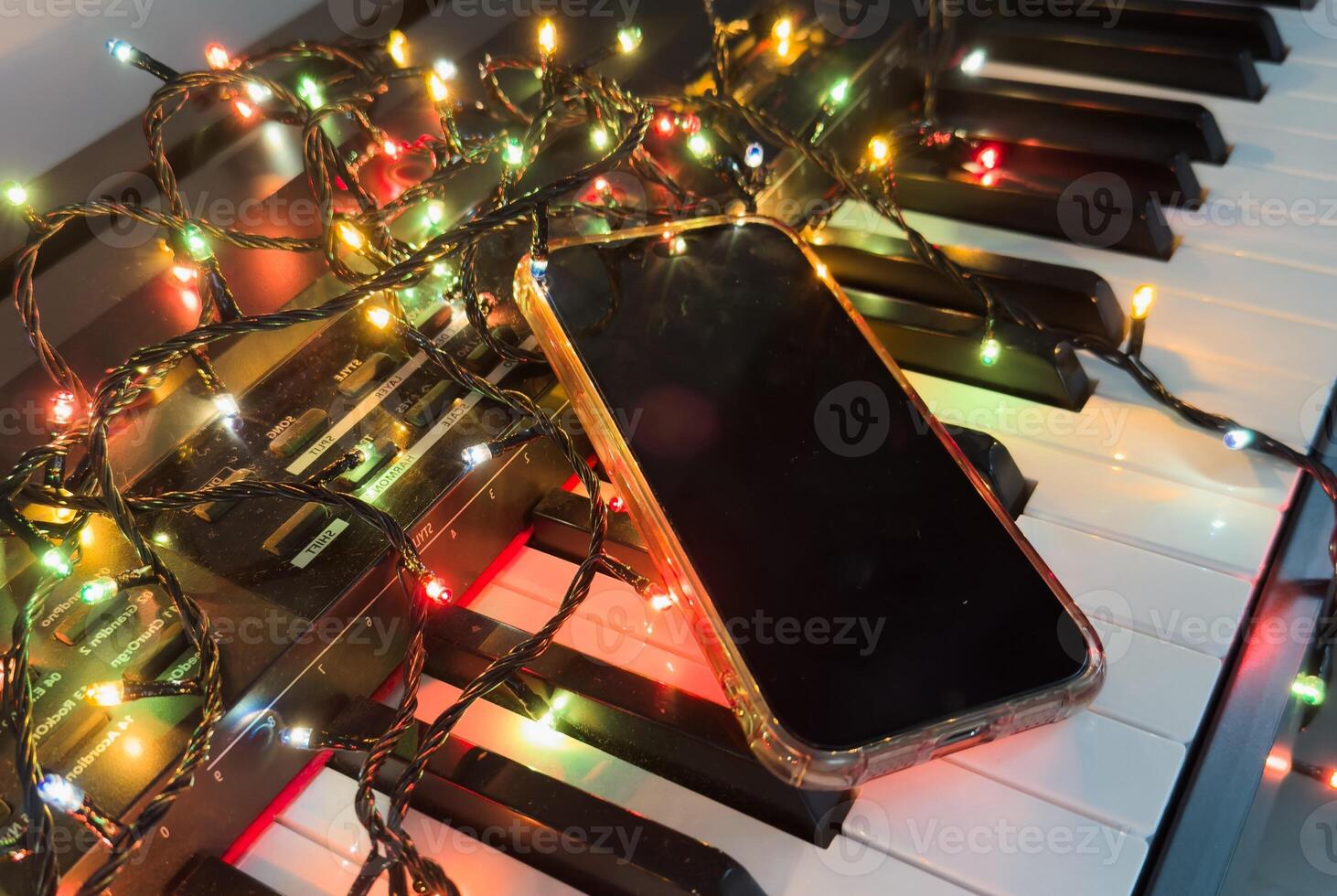 Chritmas balls and gift boxes on classical piano keyboard, smartphone photo