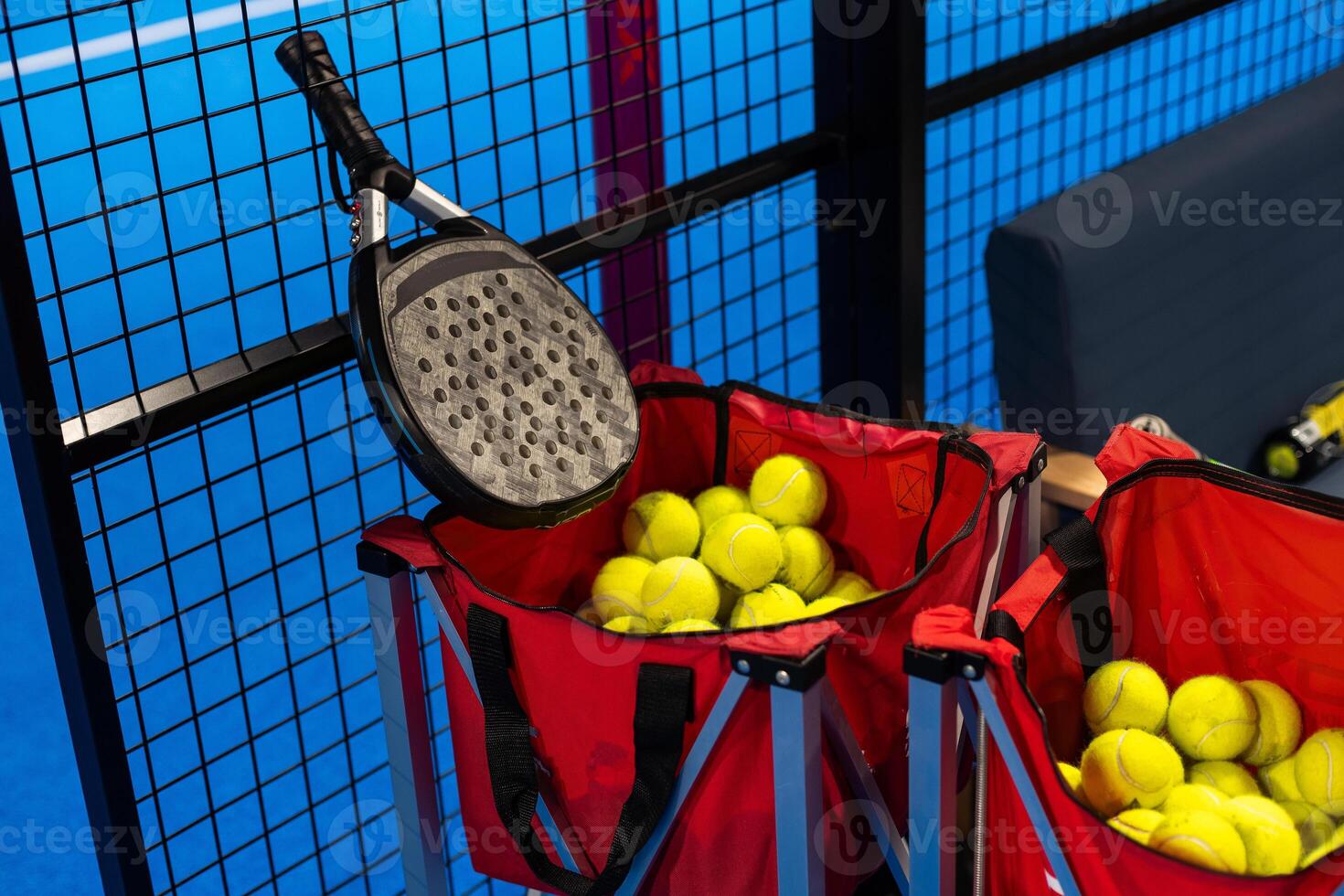 balls near the net of a blue padel tennis court photo